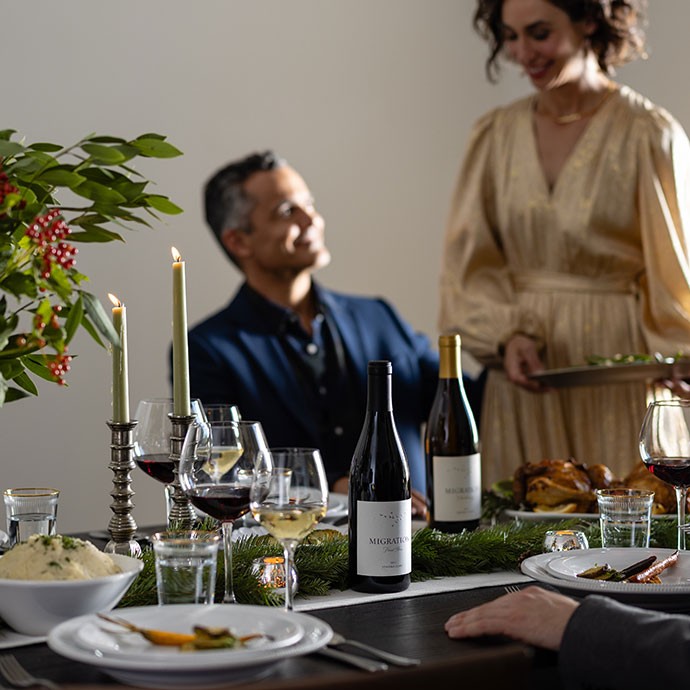 Two Migration wines on a table on a Christmas table with people
